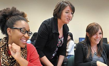 professor assisting two students in class